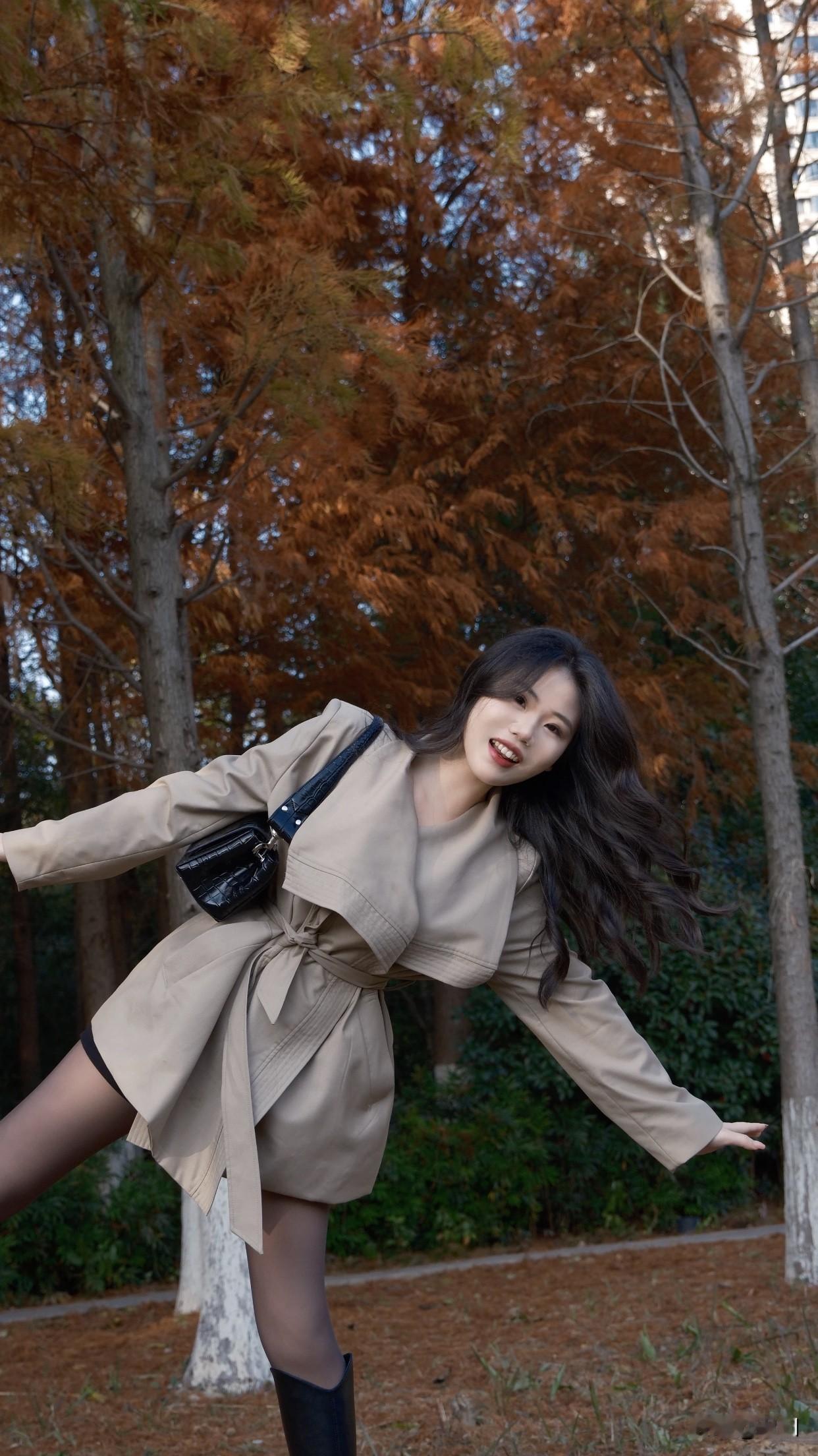 分享一张秋色的美景一个女孩在树林中开心地跳跃。