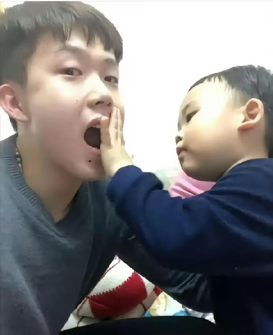 看着画面真的好暖心呀～王楚钦张着嘴巴，温柔配合小宝贝打闹玩耍，任由小朋友小手贴在