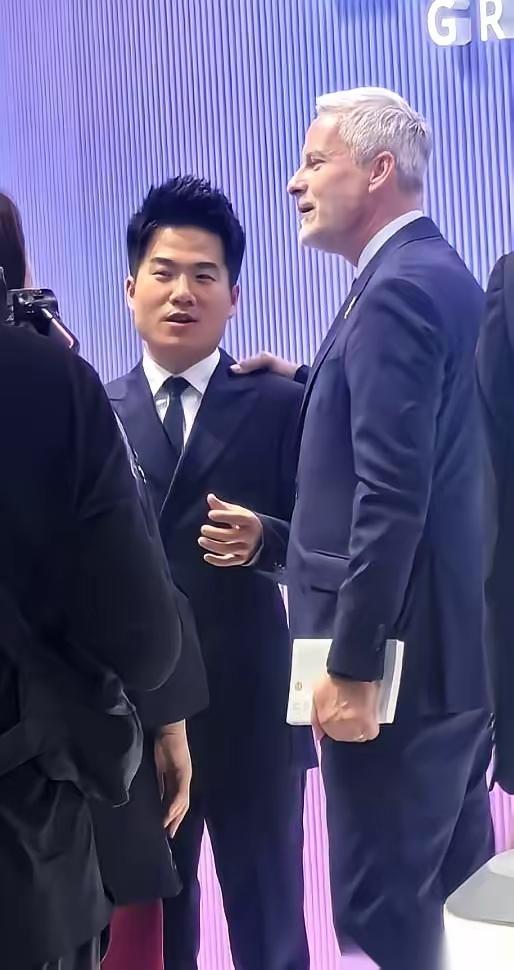 董宇辉在进博会站着就让人安心周围全是企业高管和外国代表，他穿着普通衬衫，英语