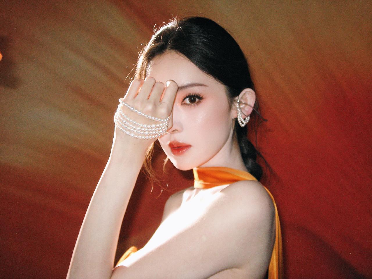 一袭暖橙曳地礼裙加身，古力娜扎站在复古拱廊间，恍若从旧时光里走来。裙摆似天边落霞