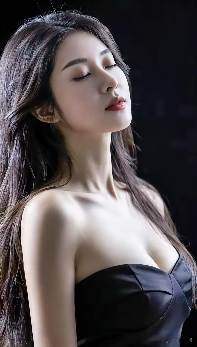 暗夜为幕，她如月光雕琢的瓷。长发垂落，似墨色溪流轻淌。抹胸承托，是优雅凝