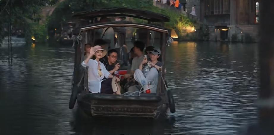 7月31日，金喜善游览浙江乌镇小桥流水人家，她坐在小船上戴了一顶帽子开心挥手，脸