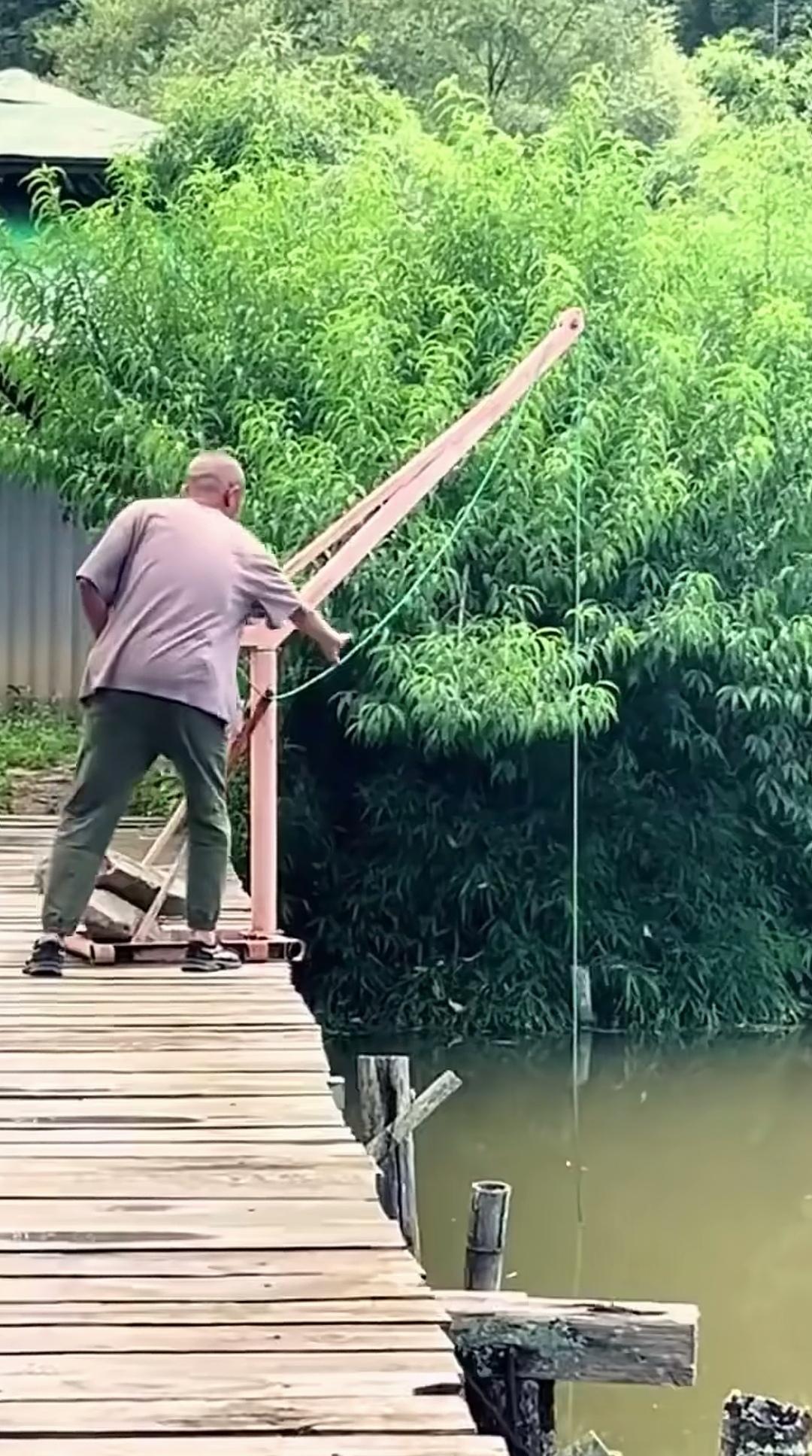 大爷果然是大爷，竟用吊运机来拉板罾网捕鱼，着实聪明。从画面能看出，他此刻用于捕