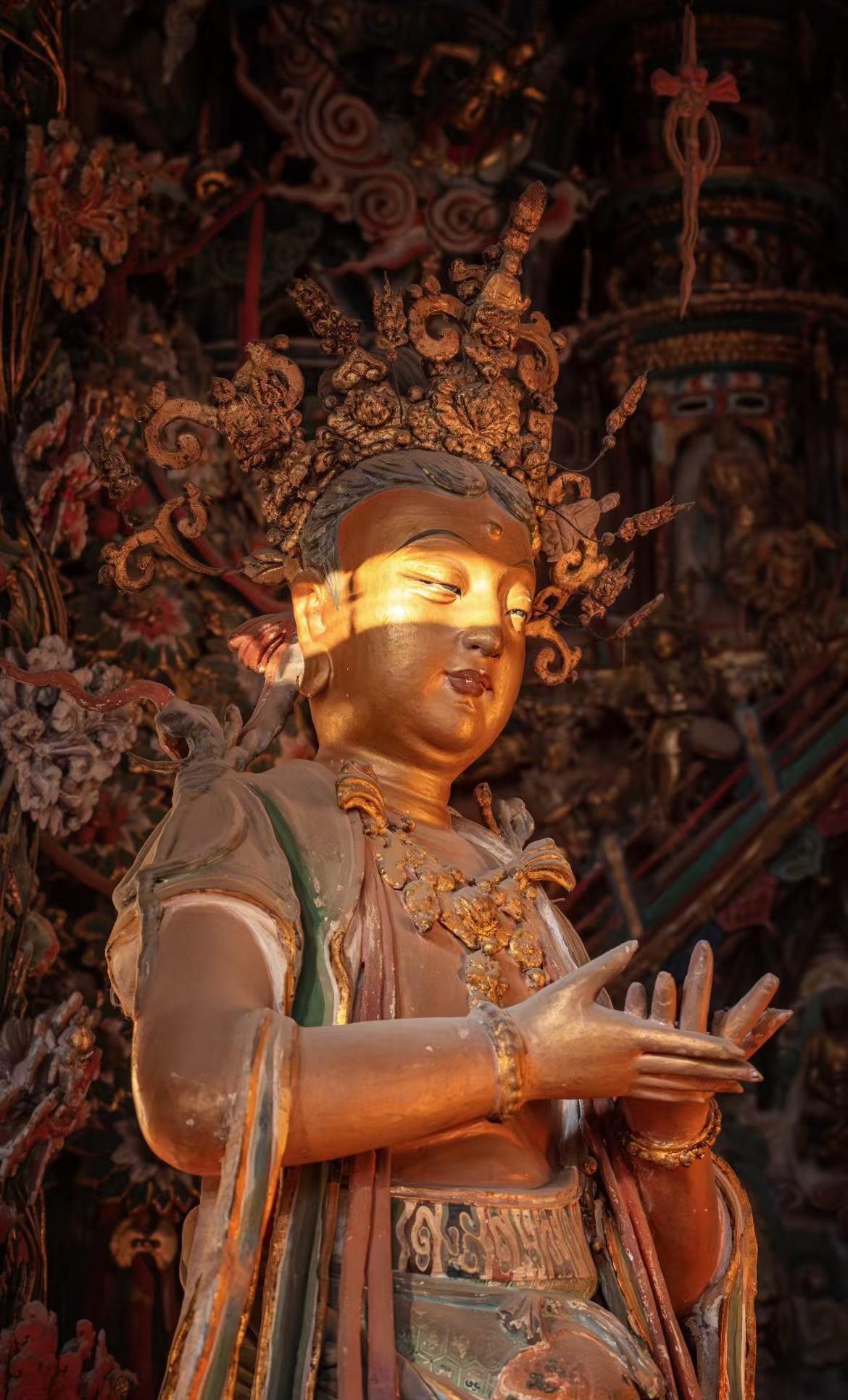 日出时分的山西隰县小西天，悬塑满堂，万象庄严，阳光映照在古老的佛像上，更是增添了