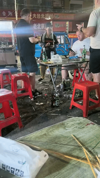 三名俄罗斯男子刚刚在夜市摊上喝完酒，吃完饭。他们纷纷掏出来手机正在各自支付饭钱