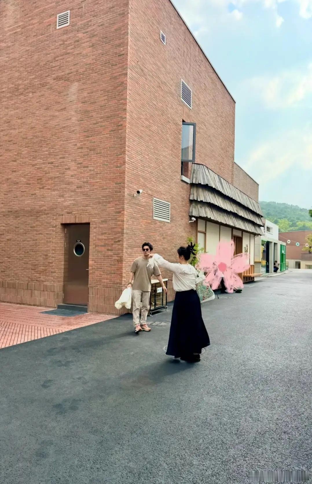 歌手李健与老婆孟小蓓出行在阿那亚，李健头发乌黑又茂密，戴一副墨镜，穿一件白色T恤