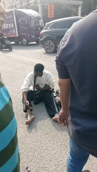 两名黑人小哥在路上出了车祸，刚刚被一辆汽车给撞了！猜测应该是两个人骑电动车速度
