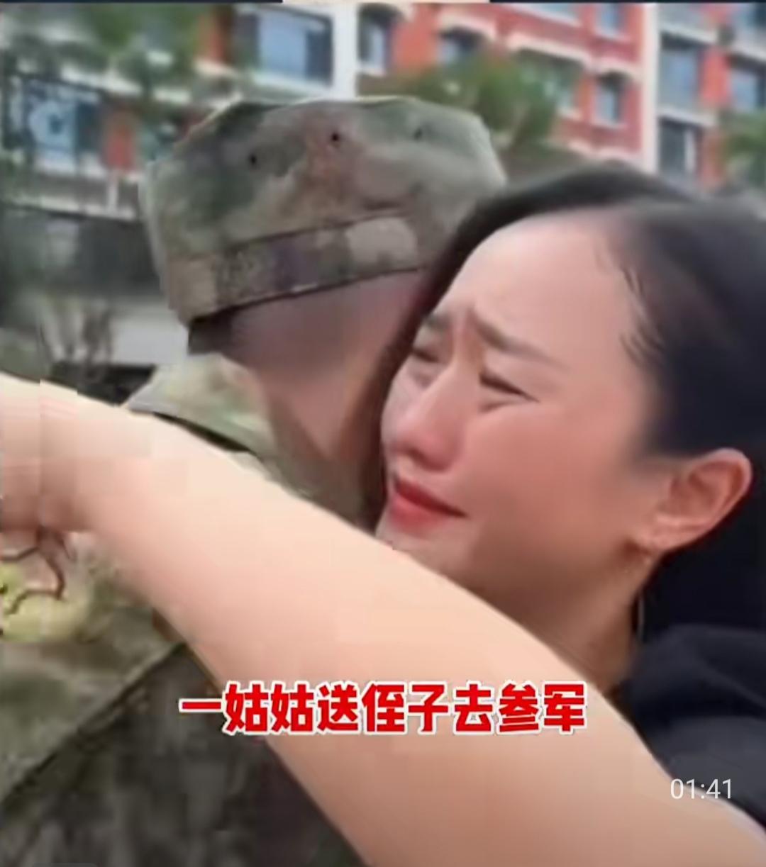 车站的征兵送行现场，人声鼎沸，身着迷彩服的新兵们昂首挺胸，身边大多是紧牵双手、反