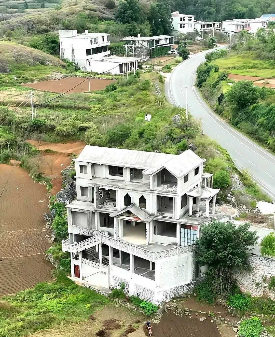 村里首富前几年花了300多万建的大别墅，到现在还是毛坯房。铁门锈得发红，