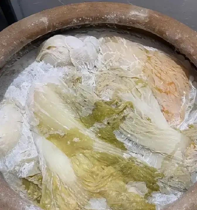网友腌酸菜忘了压石头，三十天后开盖直接傻眼，坛面漂着一层白毛衣，菜帮子从金黄变成