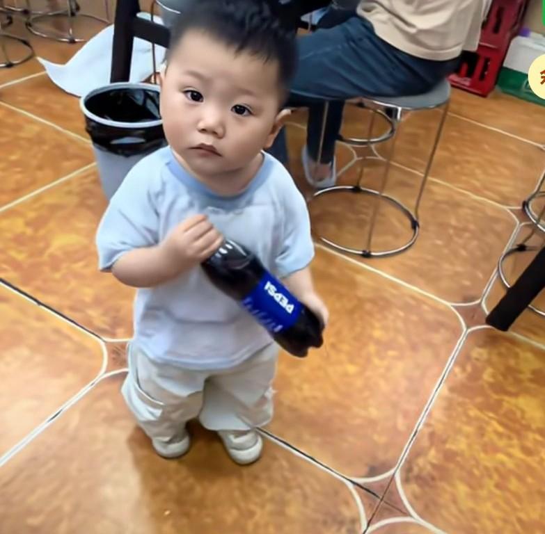 店家小孩一直拿可乐给女生，小孩子拿着可乐给女生递过去，女生说你要把你家可乐都给