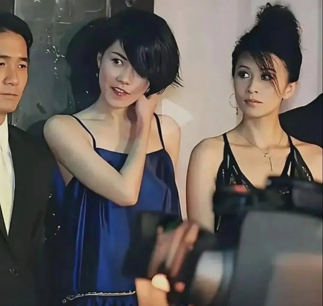 旧照里，王菲刘嘉玲梁朝伟合影，年轻时的刘嘉玲眼神就很炙热清亮，一眼就会难忘，且气场强大，王菲则温和很