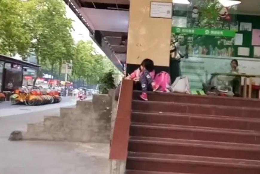 萌娃坐路边写作业: 我怕回家控制不住自己