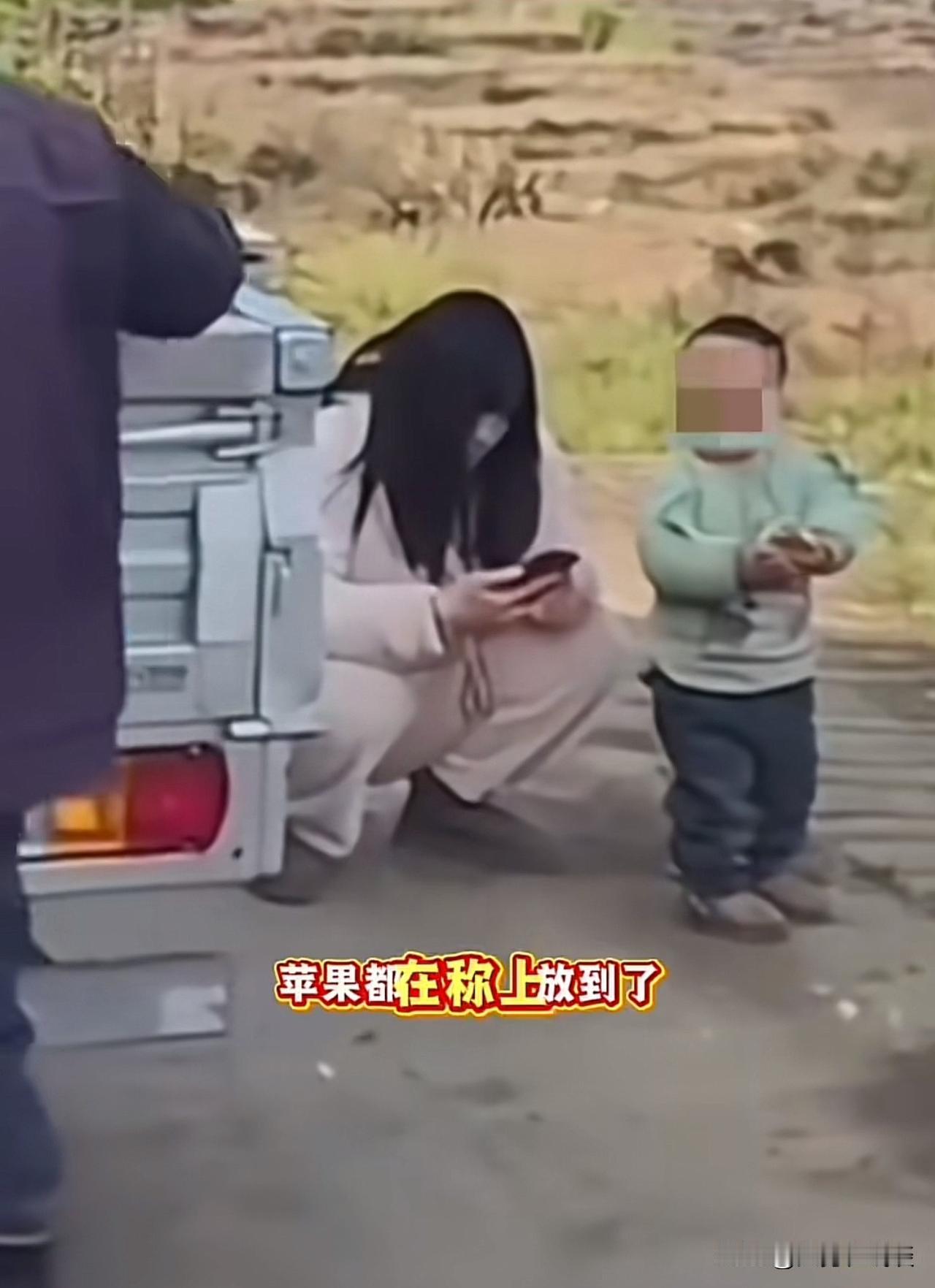 62块钱的苹果钱让人看到心酸！路人开车经过农村，一个年轻的女子穿着睡衣带着孩