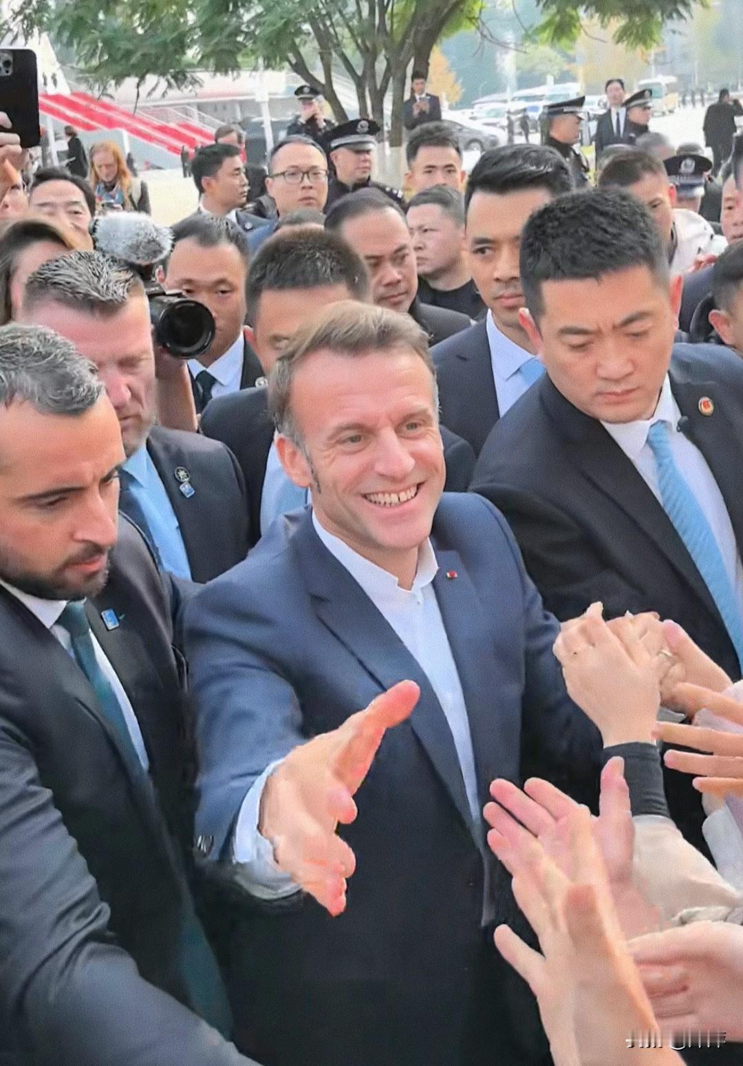 马克龙在四川大学受到热情的欢迎，同学们热情欢呼！他也很高兴和同学们握手打招呼。估
