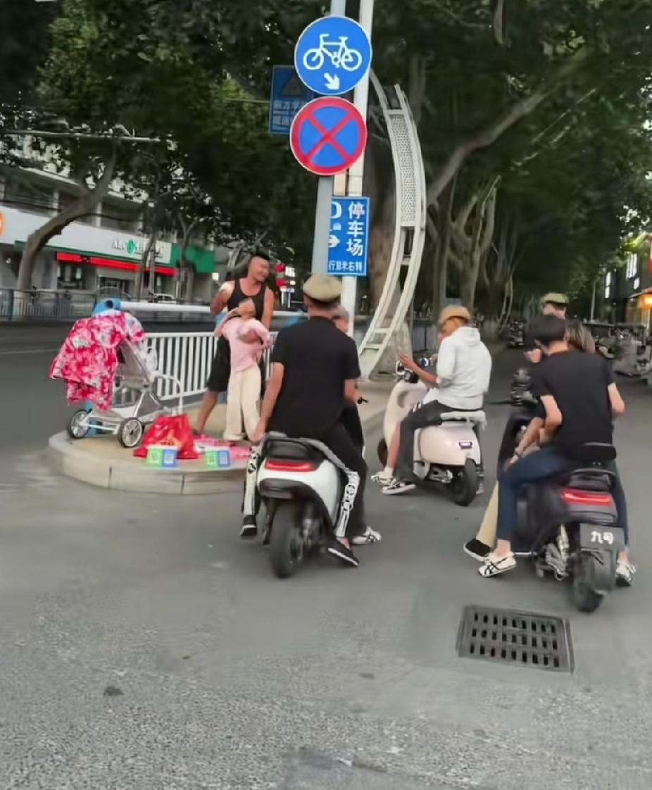 几名骑着电动车的黄毛小伙子，突然停车围住街边的男子和小女孩，接下来看到的一幕，让