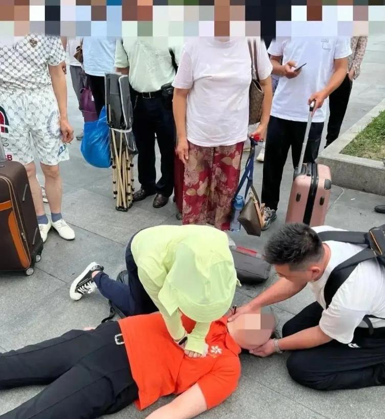 2024年7月8日，上海火车站南广场。一个男人跪在地上，怀里抱着全身青紫的妻子，