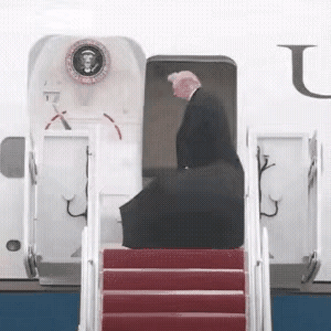 特朗普走进机舱，把伞随手丢在机舱门口，任由它在风中凌乱。从这一举动就可以看出来他