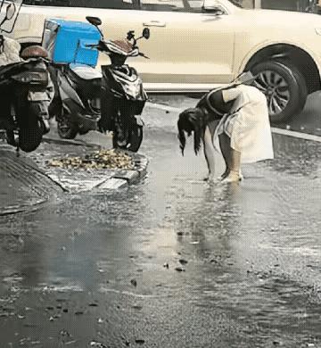 大雨倾盆，下水道的篦子被雨水冲刷的枝叶堵塞导致雨水无法进入下水道，致使路面积水越