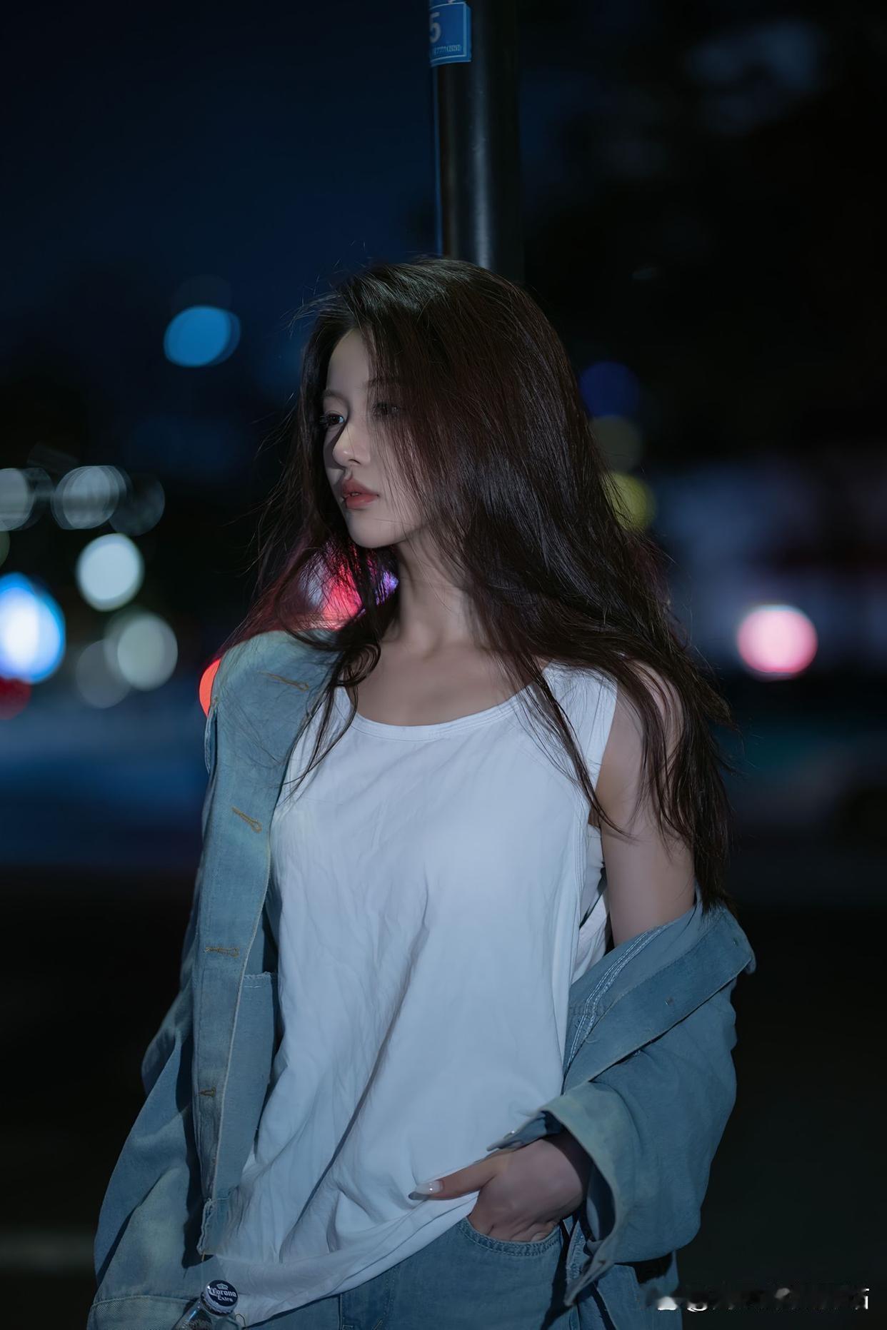 我最近随拍的这张照片，是夜晚街灯下一位轻倚栏杆的少女。夜色里，城市招牌灯光映照街