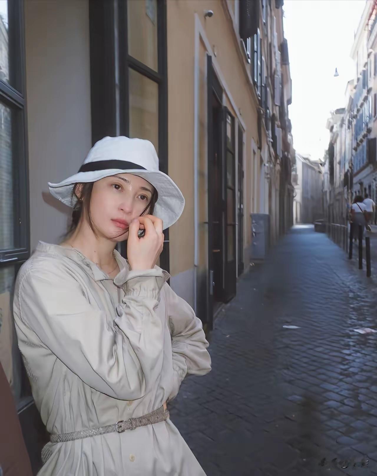 51岁蒋勤勤西班牙旅行随拍，太绝了！长款风衣潇洒利落，一顶帽子添神秘感，简约穿
