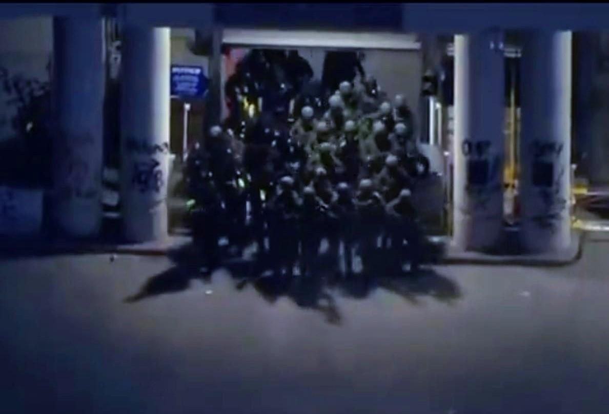 这是一张可以载入历史书的照片。全副武装的美国国民警卫队队员从一个大门里蜂拥而出