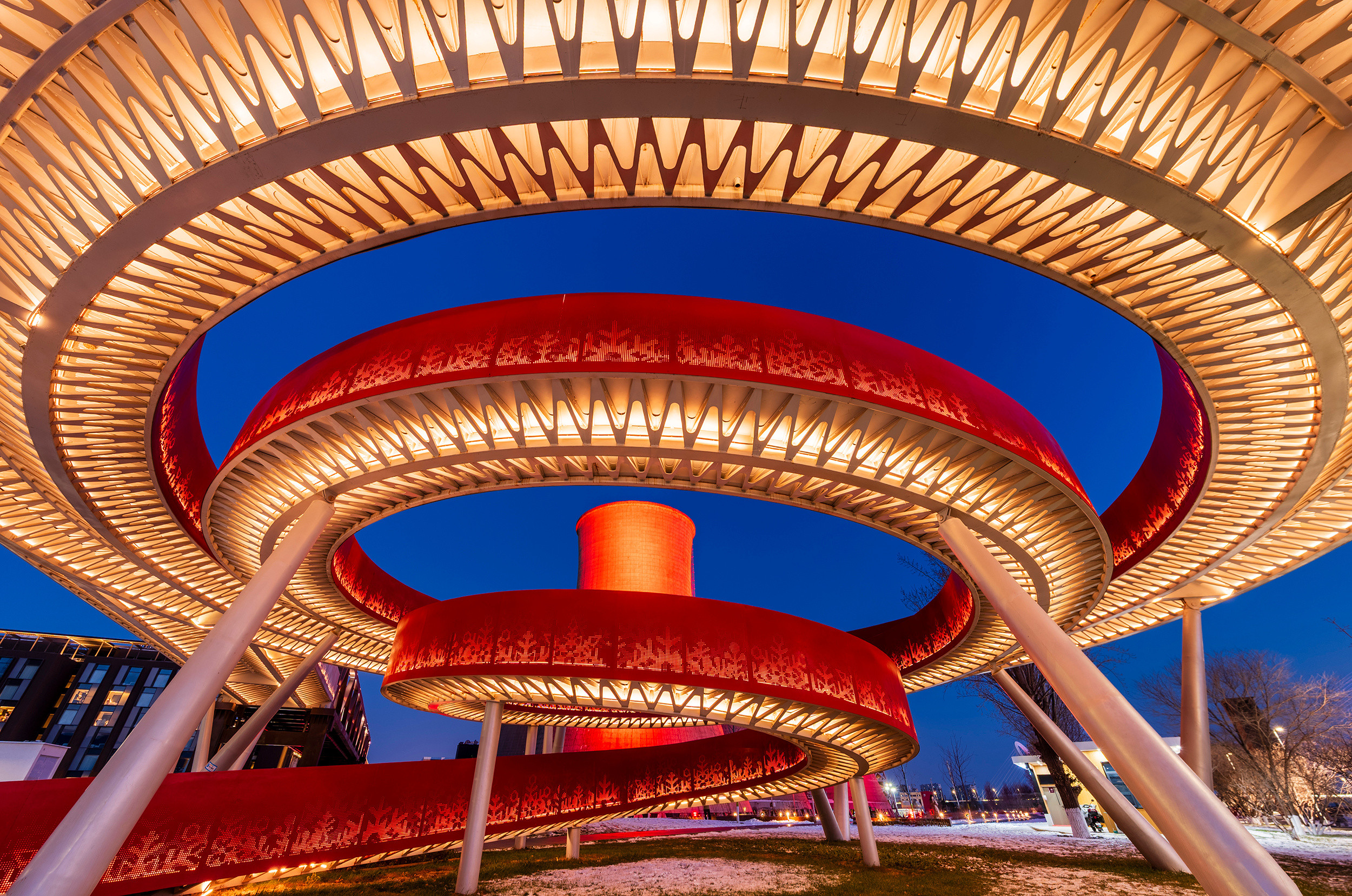 北京入冬的首钢园傍晚，雪后更是清爽。冷却塔的红色、大跳台的缤纷、首钢大桥的弧线，