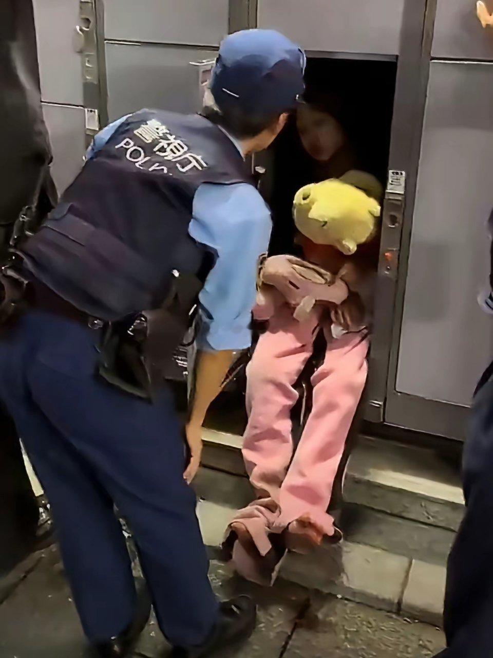 在日本歌舞伎町一名光着脚的女性抱着布娃娃以投币式寄存柜为家，在里面睡觉