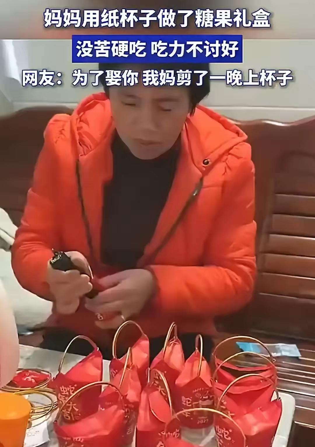 婆婆给儿子婚礼做糖盒，大红纸杯套金圈，里面是便宜糖，手工很粗糙，还熬夜做，这事儿