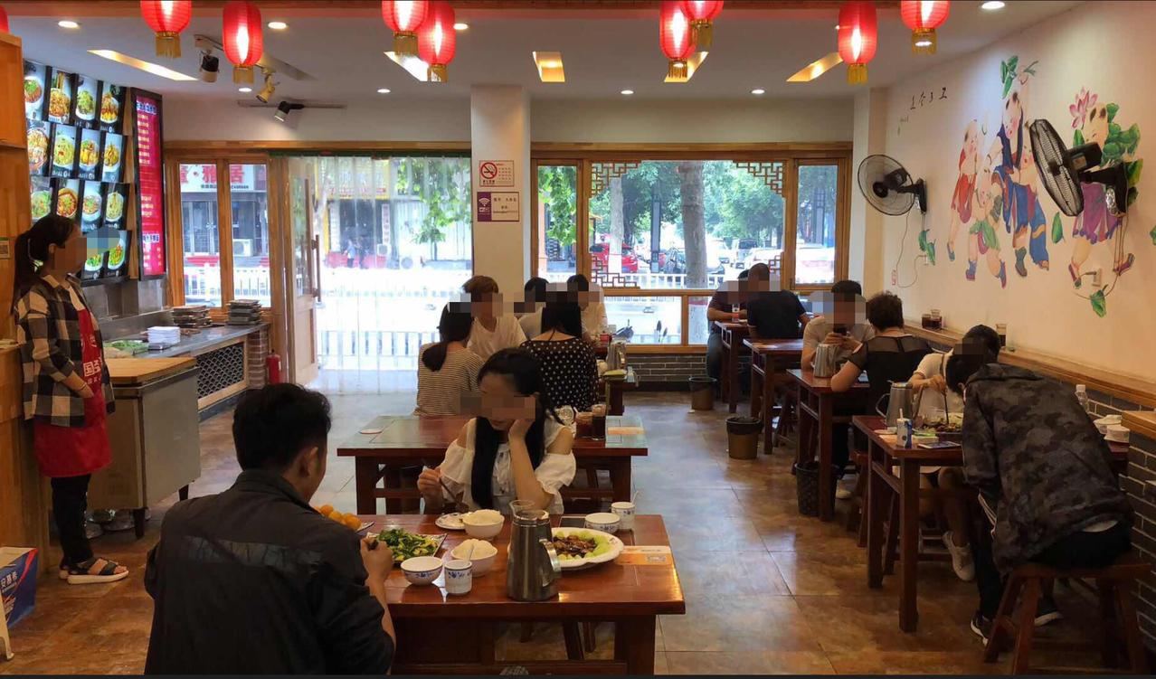 重庆，一16岁女孩穿着宽松T恤，一副中性打扮，看着像个“男孩”，和朋友在餐馆说笑