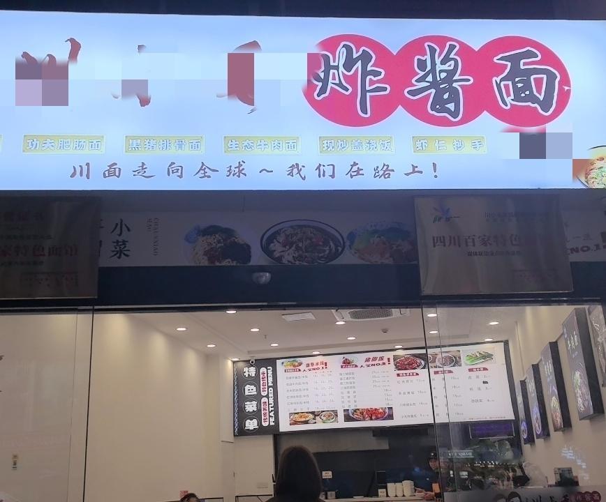 成都，一家很普通的小面馆。招牌上的口号是要走向全球！炸酱面一两16元！二两18