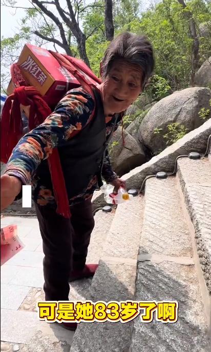 4月17日，山东邹城。一名83岁的老奶奶在峄山景区做挑山工，她每天都要背着30斤