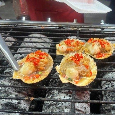 炭火一烤，蒜蓉一撒，15块钱6个的烤扇贝在美食街排着队等吃货。可谁能想到，这些肥