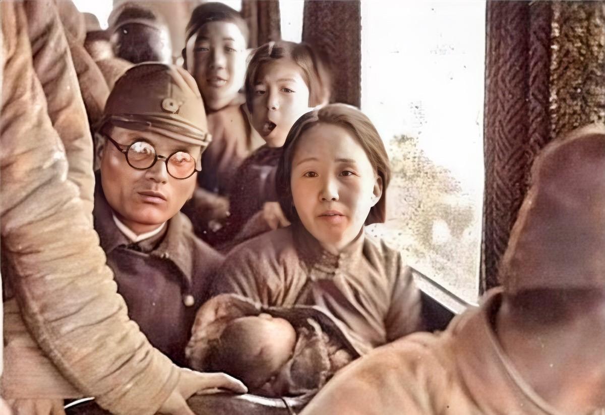 1940年，河北霸州，一名日本军官紧贴着一个抱着孩子的漂亮女人，并排坐在车上。这