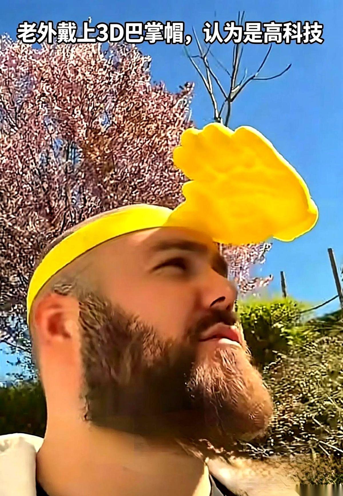 国外一哥们，举着个3D打印的“巴掌帽”在网上炫耀。镜头怼得特写，他一脸自豪：“