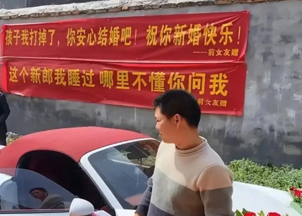 结婚当日，婚礼现场有一辆车身上拉出横幅，上面写着“这个新郎我睡过，有啥不懂来问我