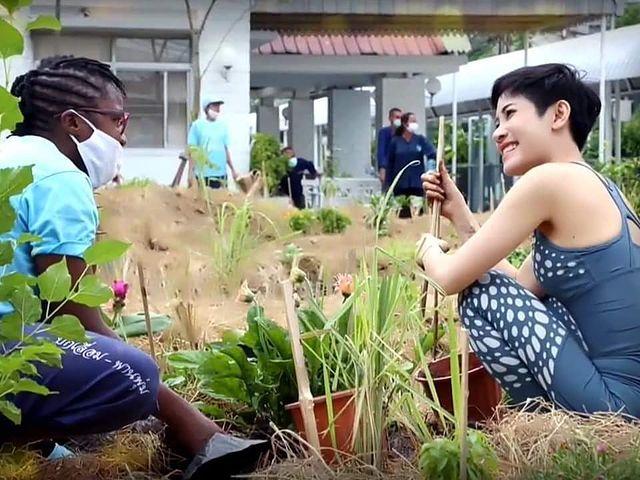 诗妮娜穿着清凉下地干活，旁边的黑人看着她笑靥如花。