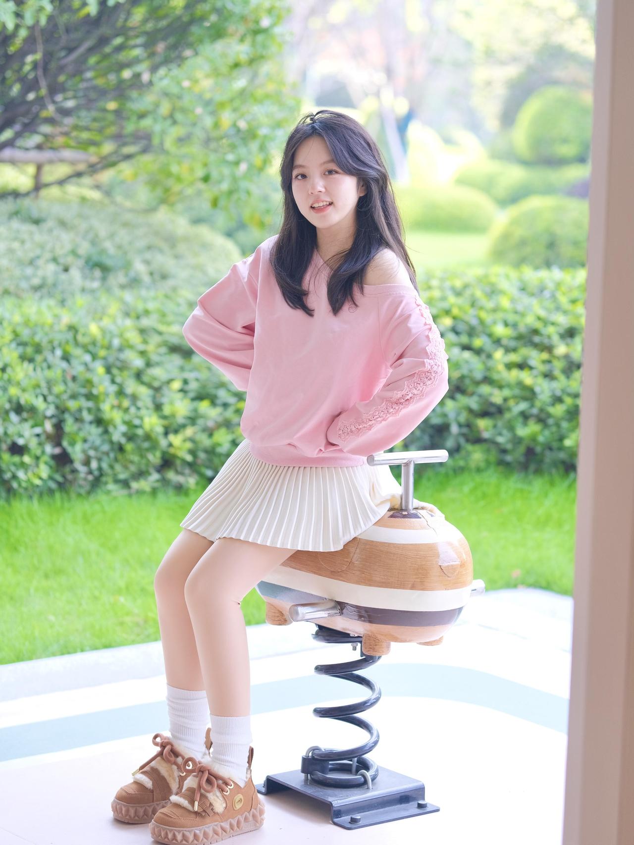 绿树掩映中，少女倚栏笑。