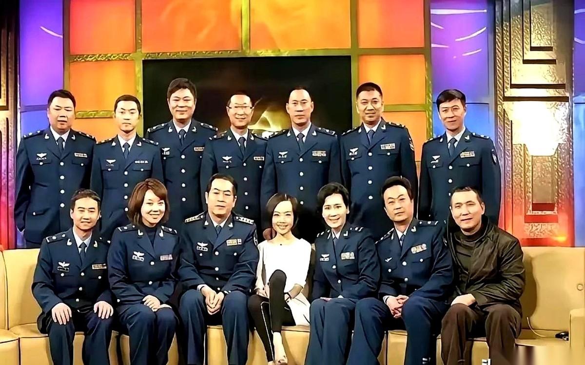 镜头扫过一排座位。左边的人，双手交叠放在大腿上，膝盖贴得严丝合缝；右边的人，腰