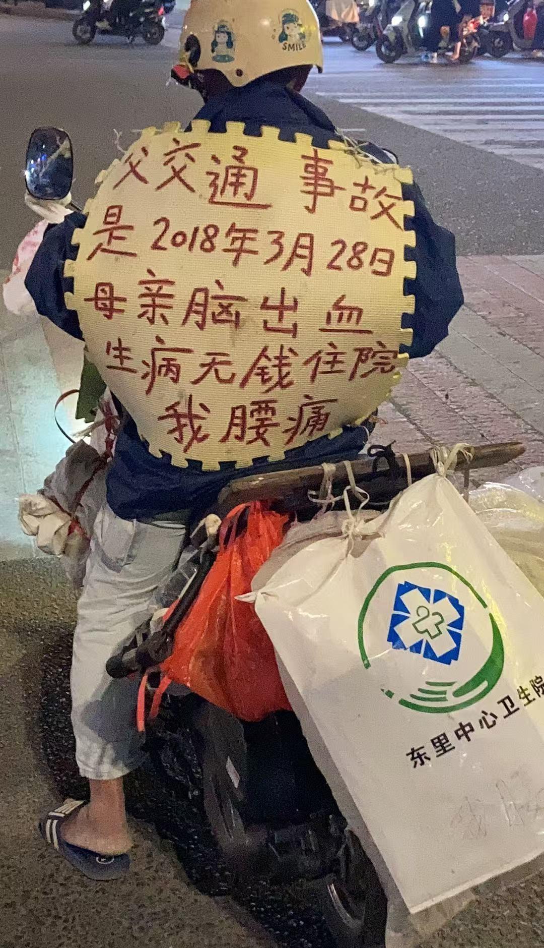 秦岭笑谈超话图中男子骑乘电动车，背后用红色字体写着：父交通事故是2018年