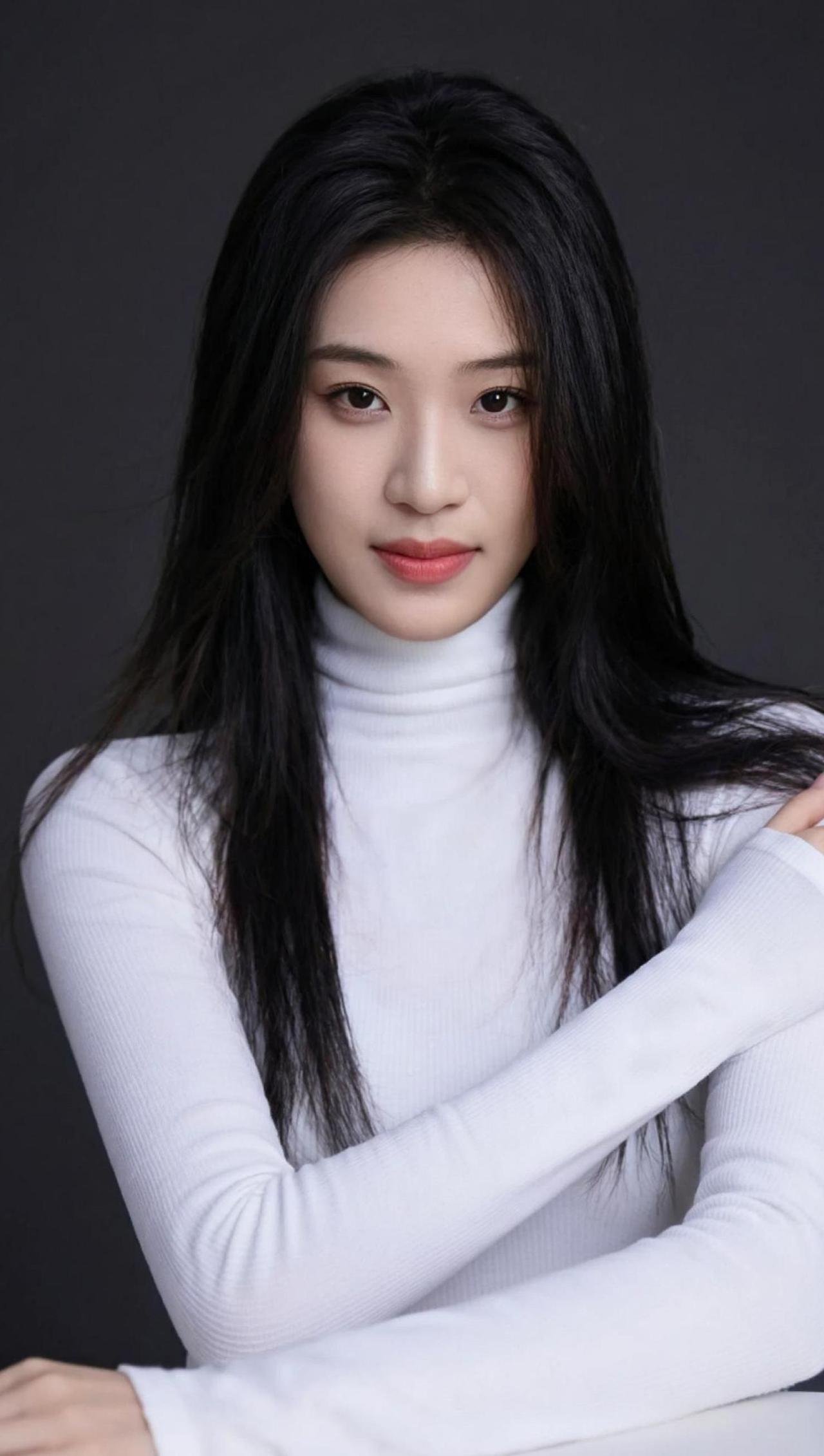 白色毛衣与黑色长发的碰撞，简约中透着一丝神秘。背景的暗色调更衬托出人物的气质，仿
