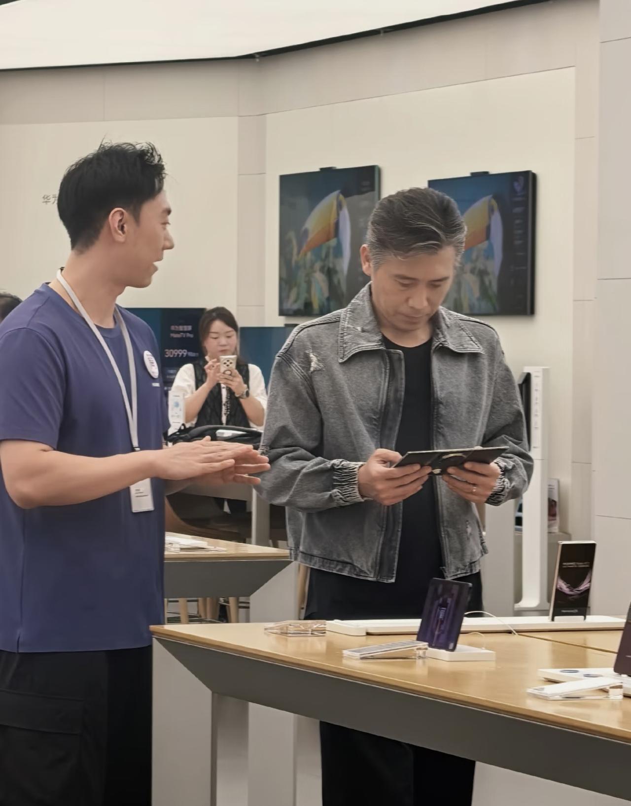 52岁李乃文现身重庆一间手机旗舰店买手机，他的穿衣打扮年轻时尚，身材很瘦，真人要