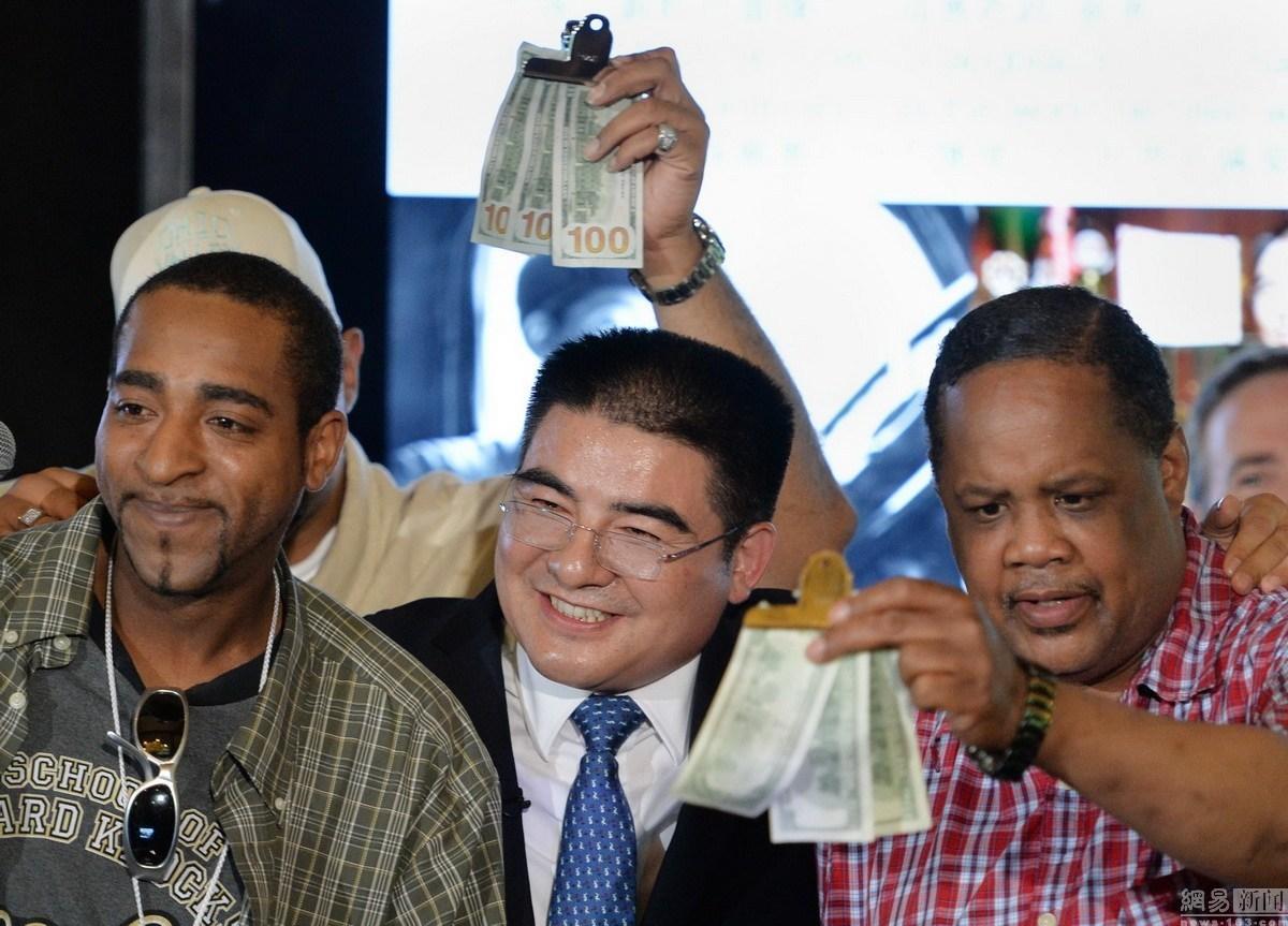 陈光标站在草屋前留影，有钱如他，草屋只是用来拍照的，豪宅才是用来住的。