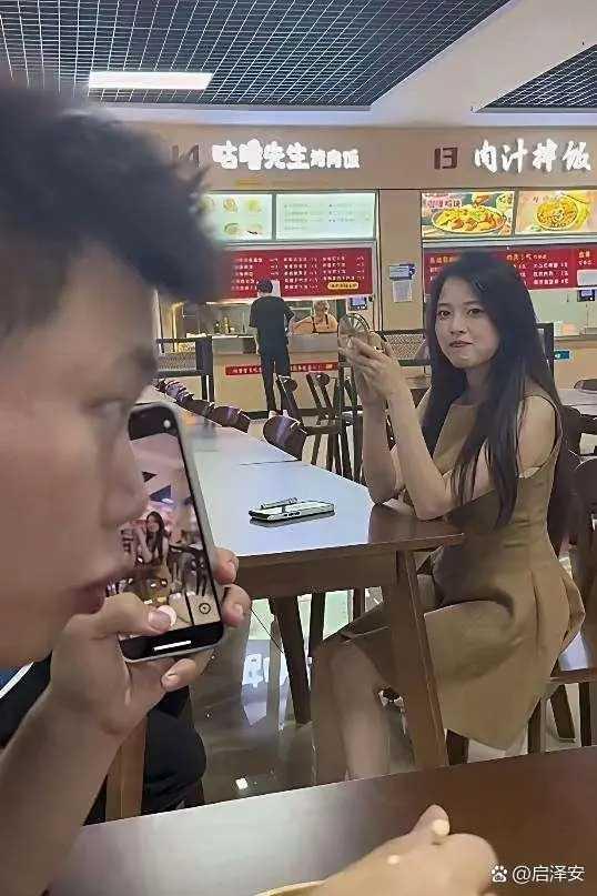 这爱不是来了吗？小食店里，小伙子被邻座的姑娘吸引了，他掏出手机，装着接电话的样