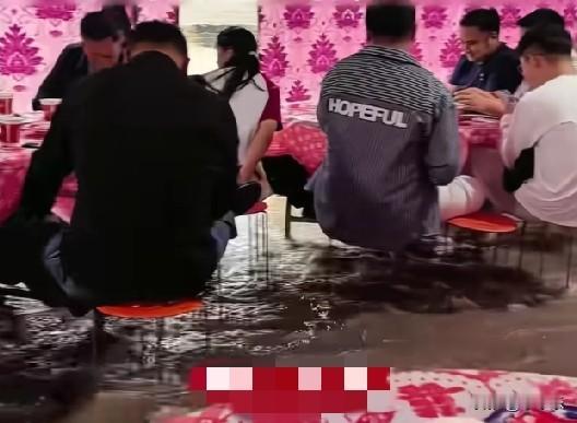 5月17日，陕西渭南，一场婚礼遇到大暴雨，宾客们坐在即将没膝盖的积水里吃席，最深