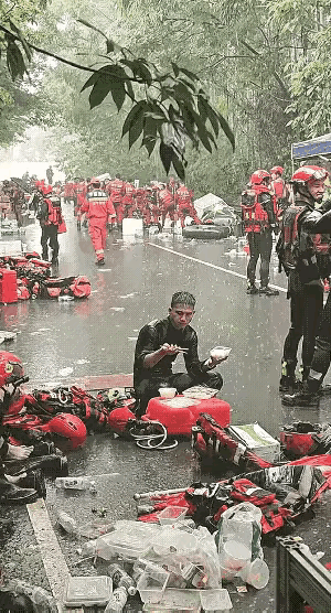 这一幕估计只有中国才能看到！广西贵港，一名消防战士在救援间隙坐在地上吃饭，突降大