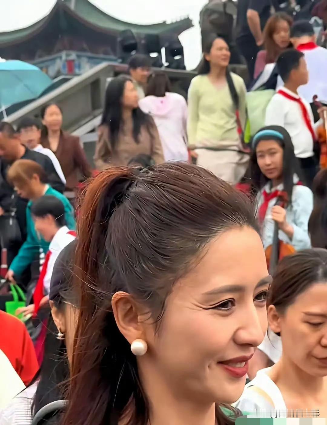 路人原相机镜头里，佟丽娅扎着利落高马尾，鬓角生出不少白发，开怀一笑时眼角皱纹格外