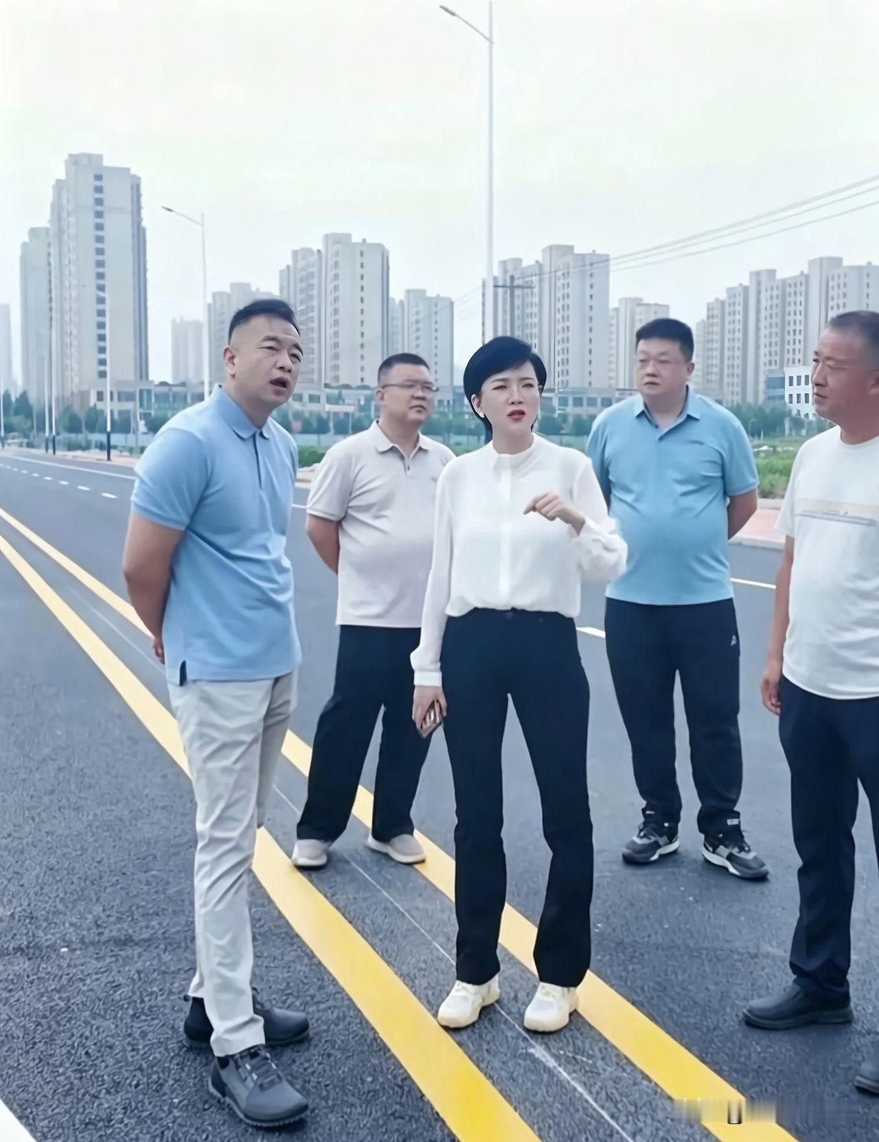 图中一群人站在一起，好像是现场办公，研究什么问题，看着都像领导，非常精干，现在领