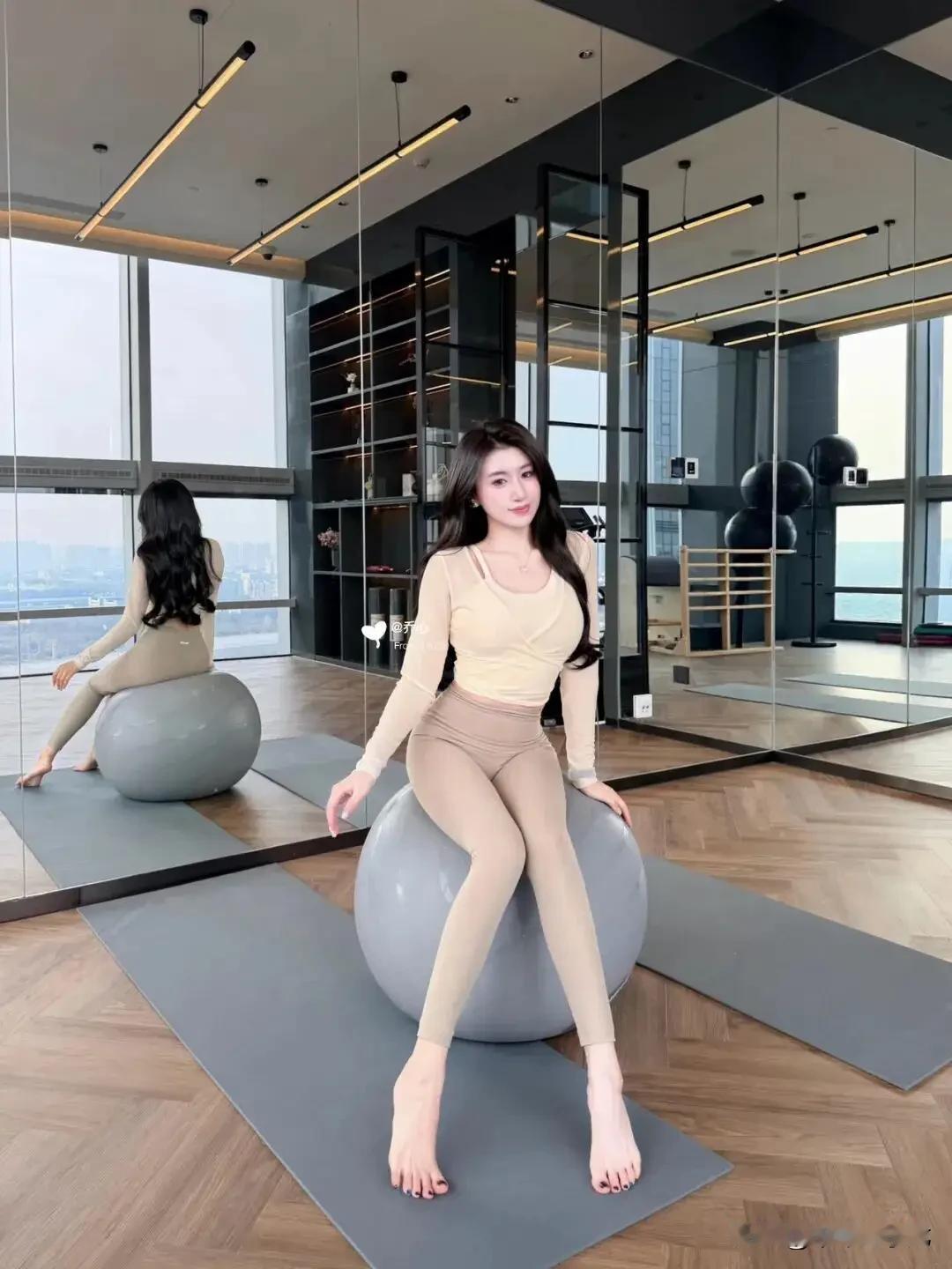 奶油交叉上衣配瑜伽裤在全景落地窗的高空瑜伽室里，整面镜面墙把城市天际线尽数