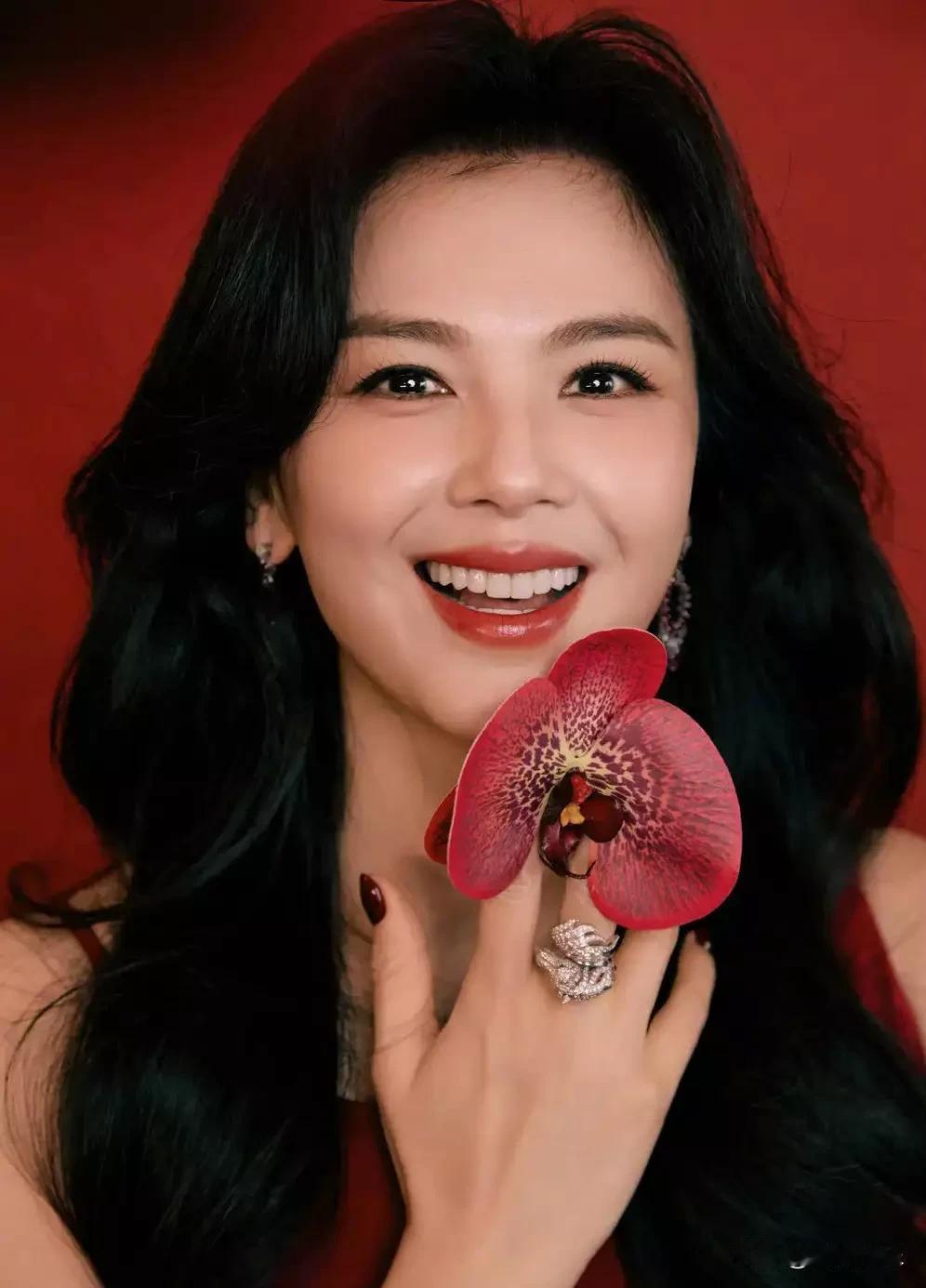 刘涛新年红裙造型杀疯了！手捧蝴蝶兰轻贴耳畔，红裙配黑卷发慵懒又妩媚。网友：这才是